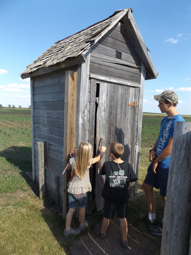 The kids waiting to use the functional, two-seater outhouse.